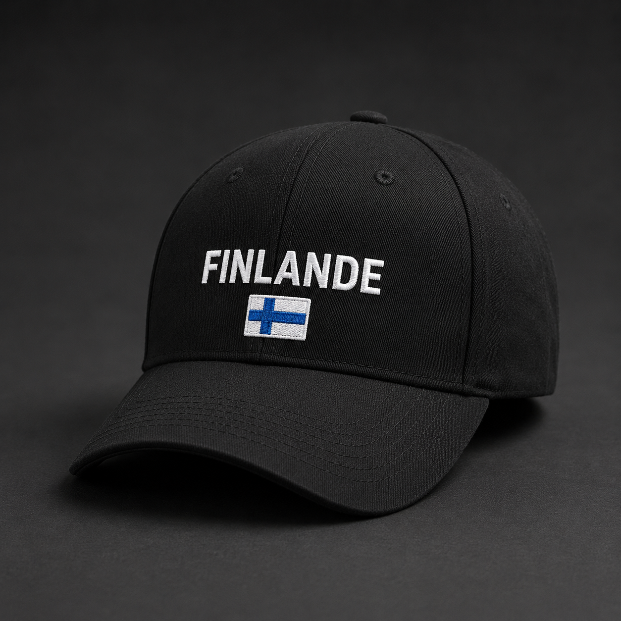 Musta brodeerattu lippis, jossa valkoinen FINLANDE-teksti ja pieni sinivalkoinen Suomen lippu