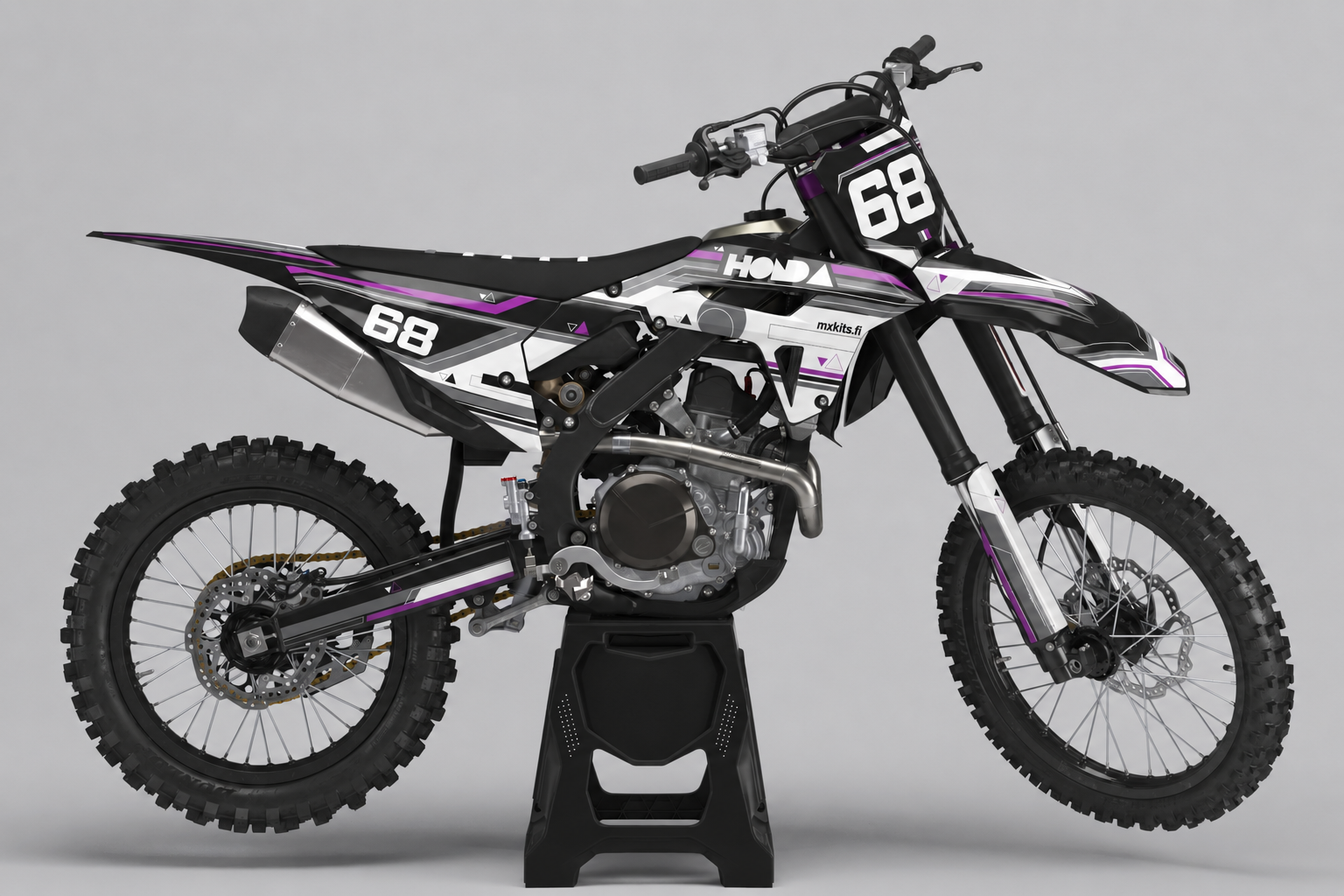 Mustavalkoinen Honda violetin geometrisin leikkauksin, numero 68 edessä ja takasivulla sekä pieni mxkits.fi-merkintä sivussa.