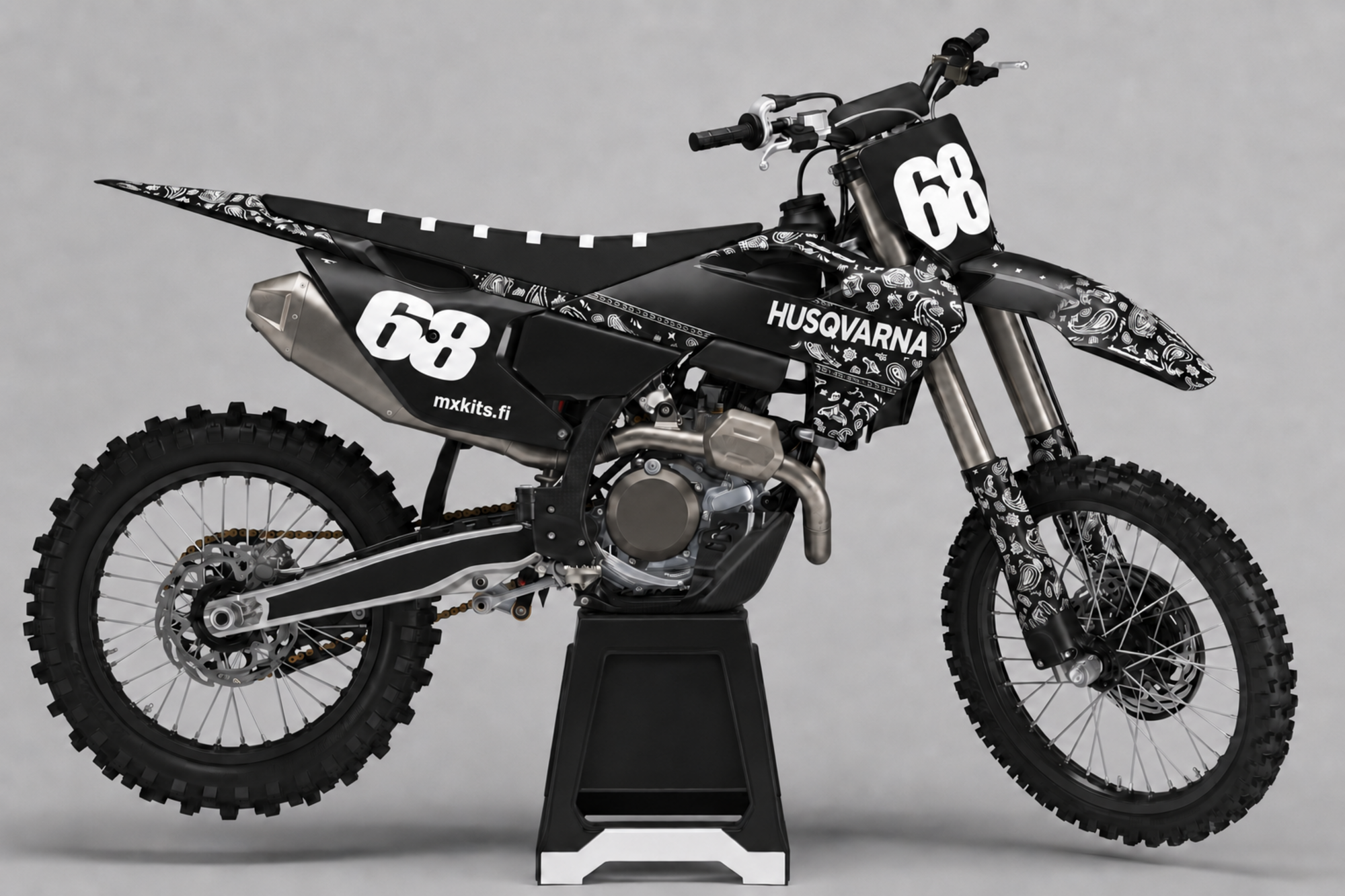 Musta Husqvarna-motocrosspyörä valkoisella paisley- ja bandanaornamentilla, valkoiset numerot 68 edessä ja vasemmalla takana, HUSQVARNA ja mxkits.fi.