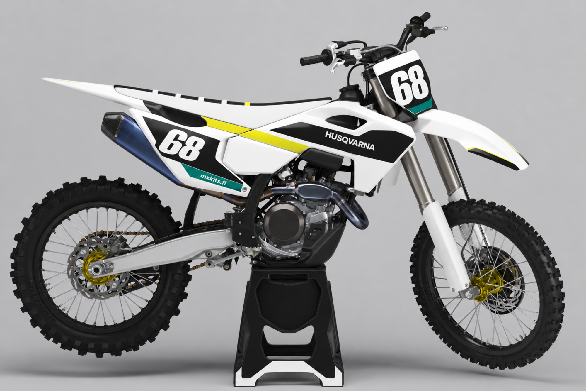 Valkoinen ja musta Husqvarna-motocrosspyörä keltaisella vinoviivalla, turkoosilla sivuaksentilla, kultasävyisillä navoilla ja sinertävällä äänenvaimentimella, valkoiset numerot 68, HUSQVARNA ja mxkits.fi.