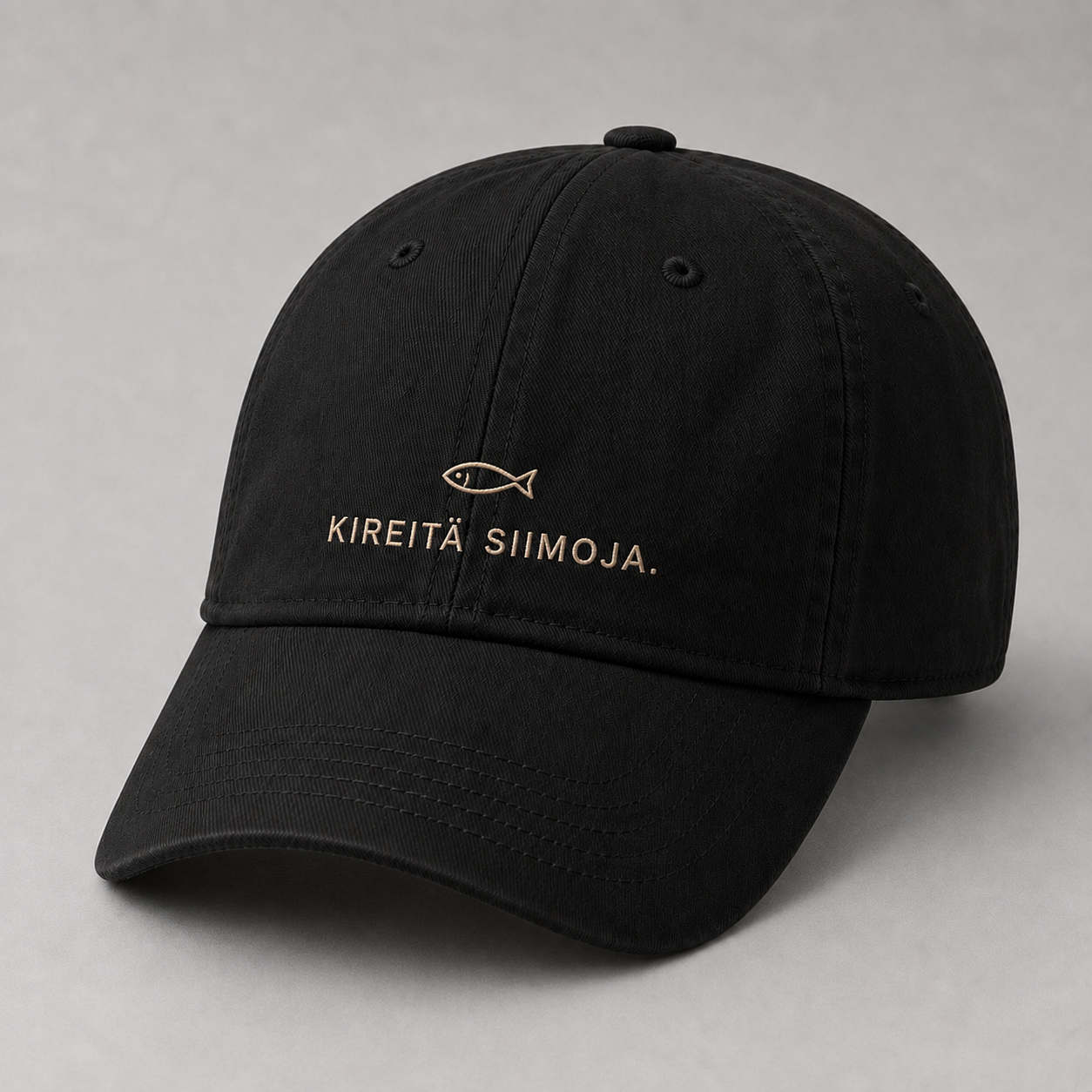Musta brodeerattu kalastuslippis, jossa pieni kala ja teksti KIREITÄ SIIMOJA.