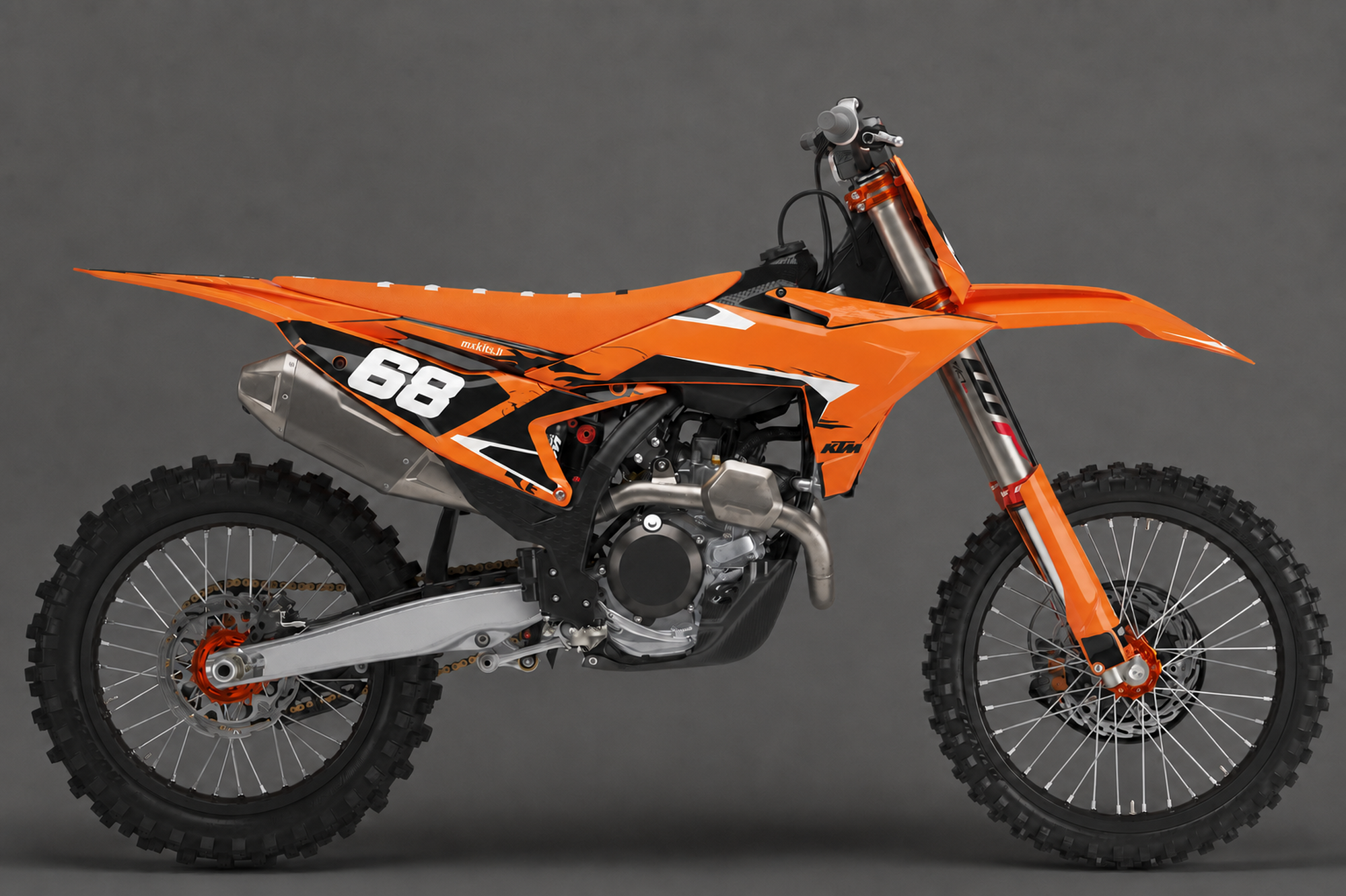 Oranssi KTM-motocrosspyörä sivulta Aamunroihu-grafiikalla, terävät mustat ja valkoiset kuviot, suuri valkoinen numero 68 ja pieni mxkits.fi satulan alla.