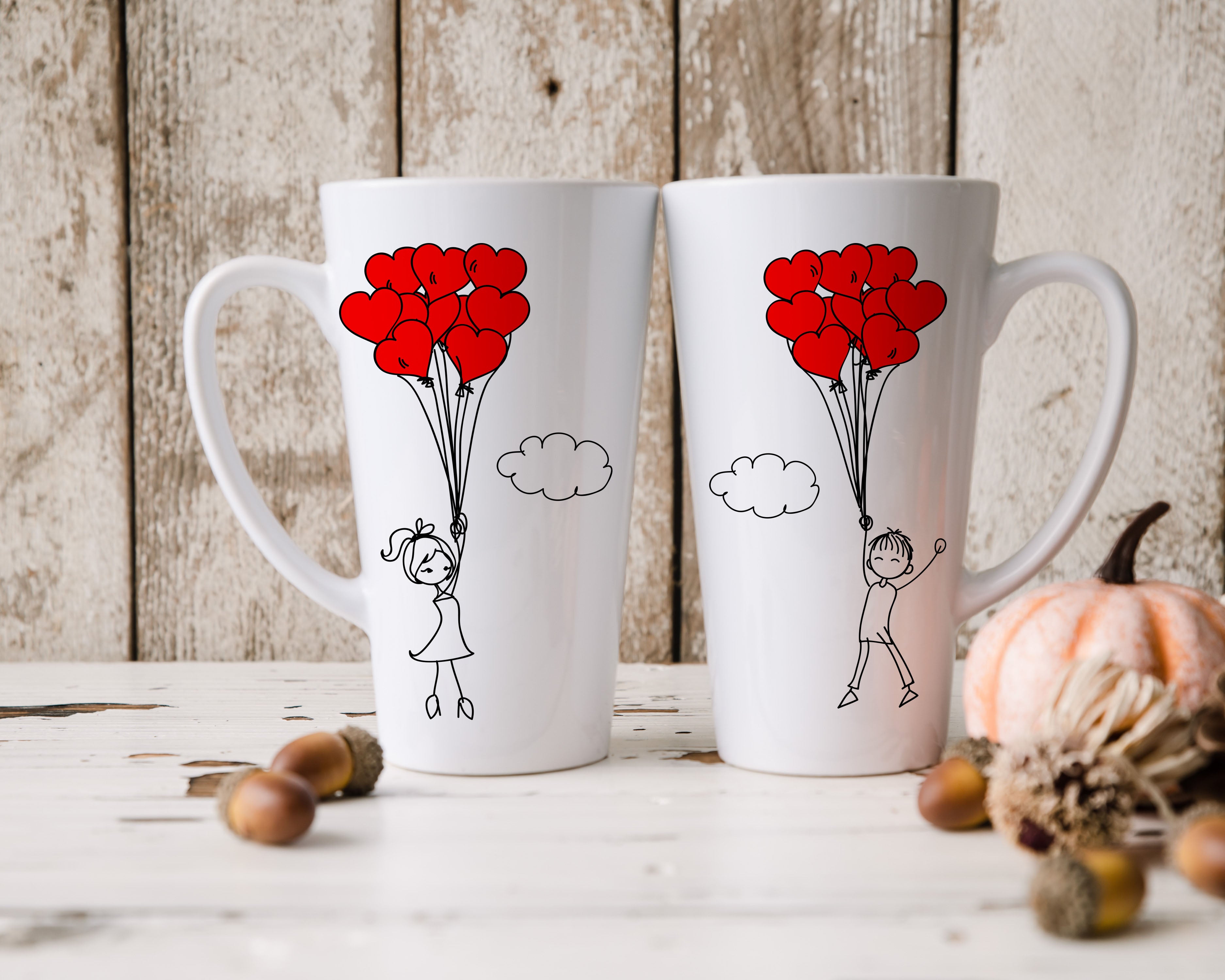 Kaksi rakkausteemaista latte-mukia sydänilmapallo-kuvituksella